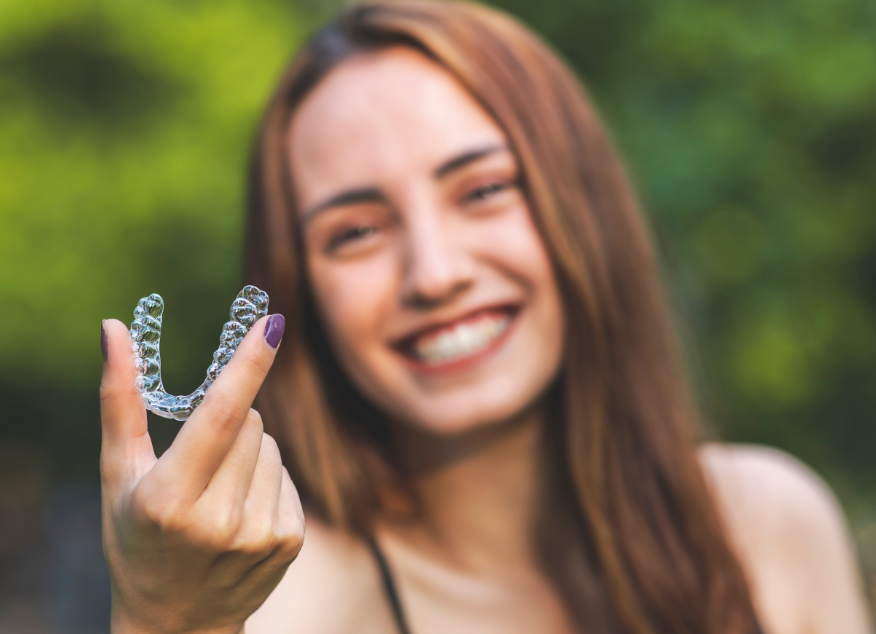 Woman holding Invisalign aligner