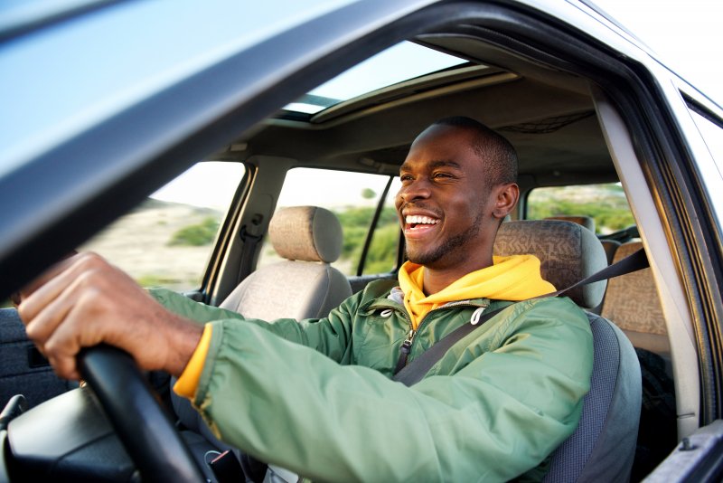 Man smiles in car
