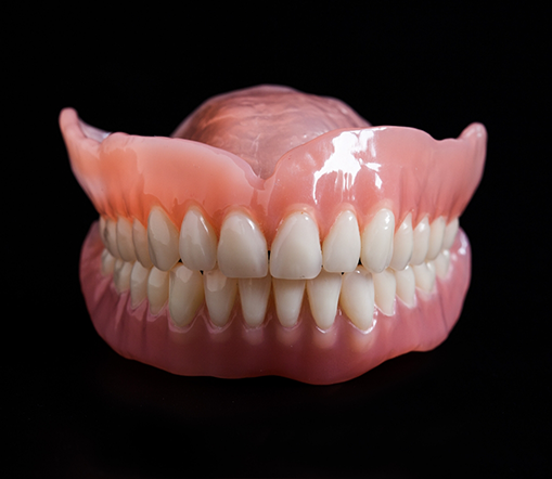 Full dentures sitting on a black background