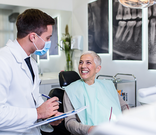 Female dental patient smiling up at dentist